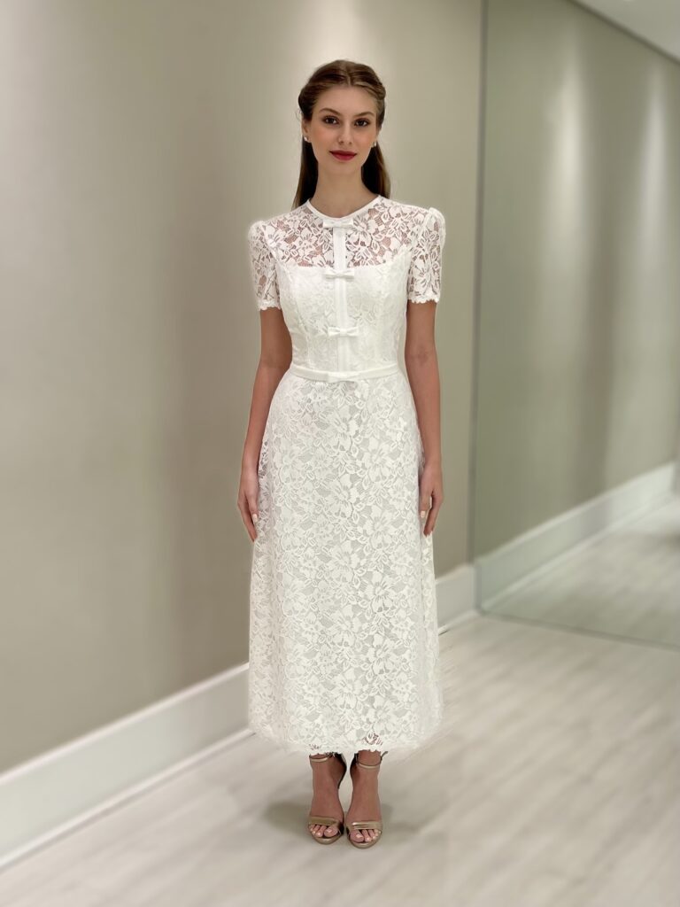 Vestido midi off white em renda com mangas curtas, gola fechada e laços frontais