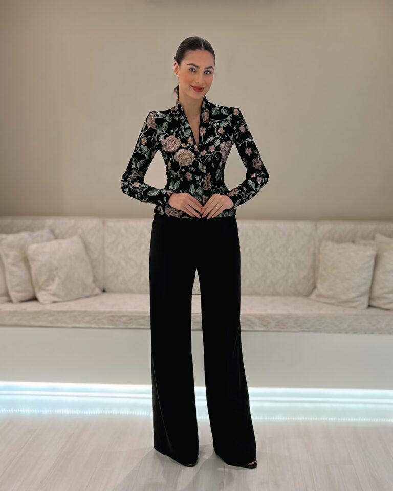 Modelo vestindo calça pantalona preta de caimento amplo combinada com camisa floral