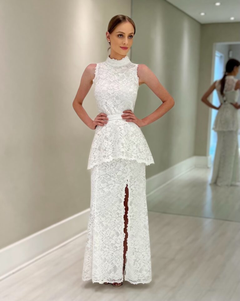 Vestido longo de renda off white sem mangas, com gola alta, basque na cintura e fenda frontal