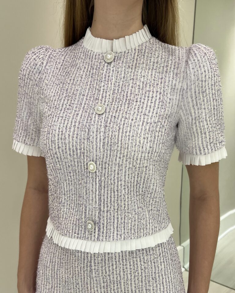 Blusa Micaela em tweed lilás com mangas curtas e acabamentos plissados na gola, mangas e barra