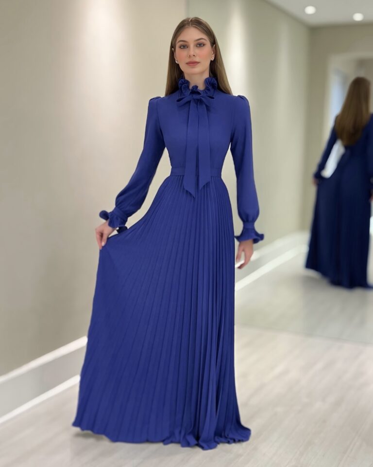 Vestido longo azul em crepe com gola alta de laço, mangas bufantes e saia plissada