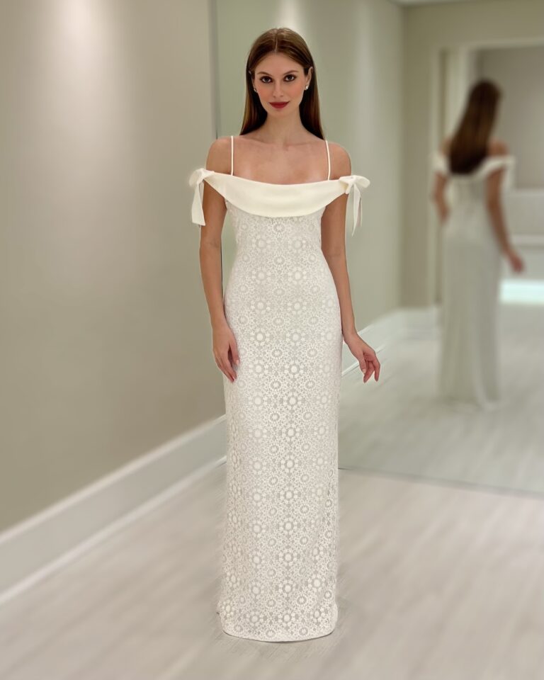 Vestido longo branco em renda com alças finas e laços nos ombros, silhueta ajustada até o chão