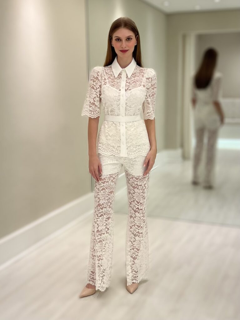 Camisa branca em renda floral com gola clássica, botões frontais, mangas levemente bufantes e cinto