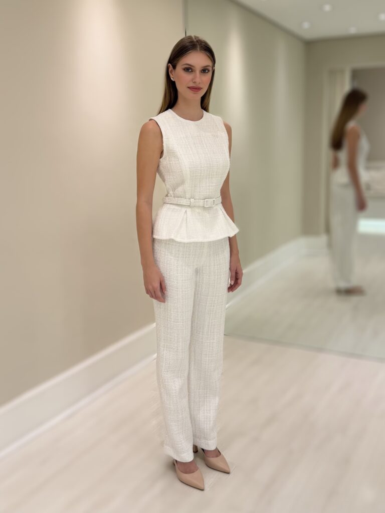 Blusa Lucy branca sem mangas em tweed, com peplum e cinto fino com fivela na cintura