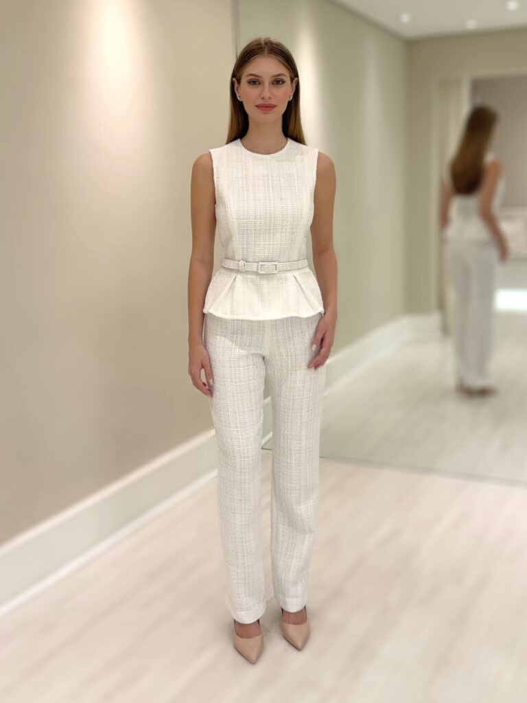 Modelo usando calça reta branca de tweed com top branco sem mangas e salto neutro