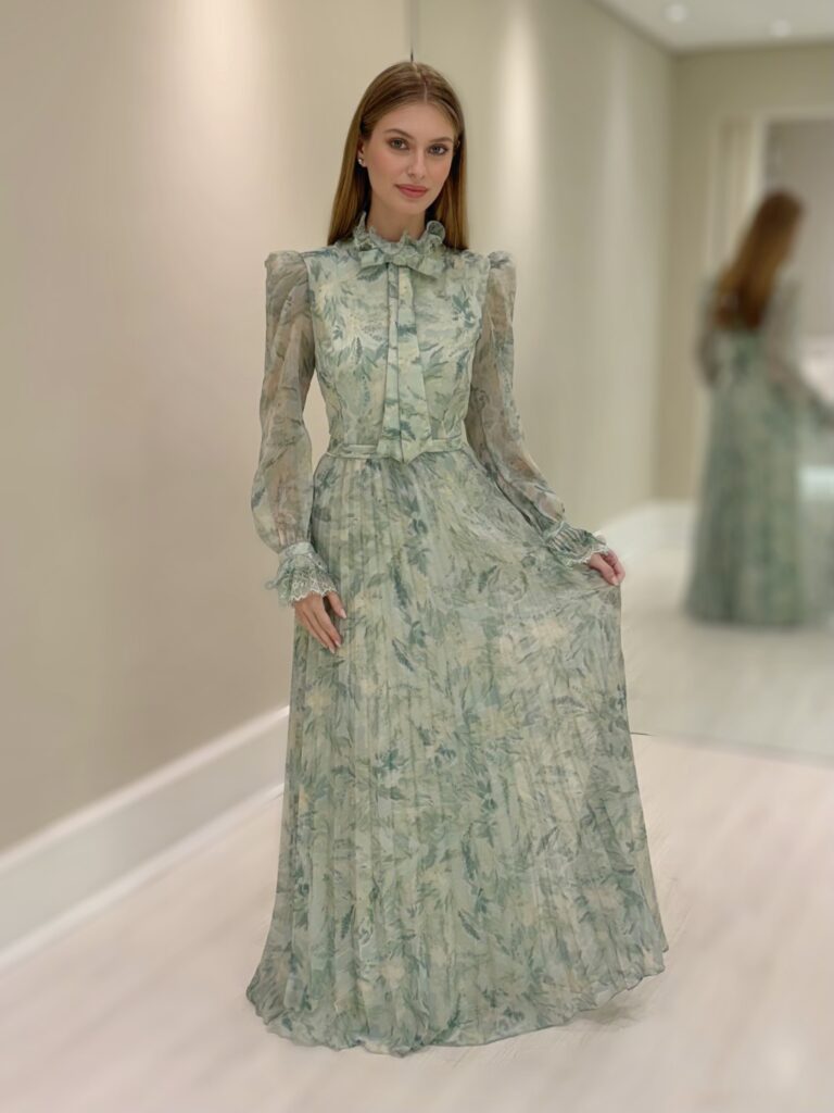 Vestido longo verde com estampa floral, saia plissada, gola com laço e mangas longas