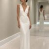 Modelo usando vestido longo off white com busto drapeado e saia fluida em ambiente interno